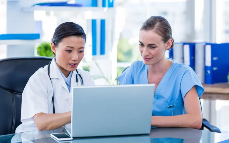 Doctor and nurse looking at laptop in medical office