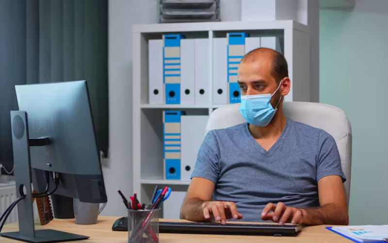 young-manager-with-protection-face-mask-working-alone-office-social-distancing-entrepreneur-new-normal-personal-workplace-corporate-writing-computer-keyboard-looking-desktop_482257-12841